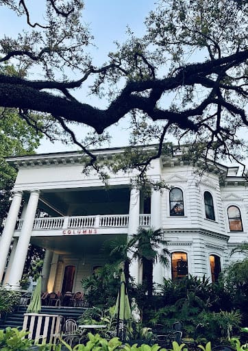 Outside of a white, historic hotel